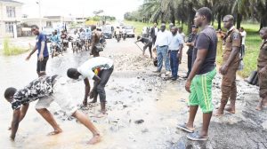 Exemplary Future Leaders: Some FUNAAB Students drafted to the flooded part of Alabata/Camp Road by their Dean, Professor Babatunde Idowu assisting with manual repair