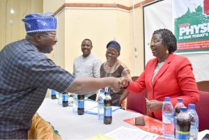 Representative of the Vice-Chancellor and Deputy Vice-Chancellor, (Academic), Professor Morenike Dipeolu in a warm hand shake with the Keynote Speaker, Professor Adeniyi Olowofela at the event