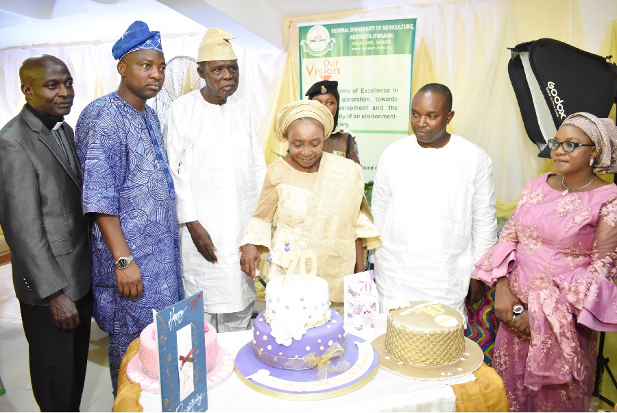 Prof. (Mrs.) Mobolaji Bankole flanked by Principal Officer of the University and relations cutting her 70th Birthday and Send Forth cake.